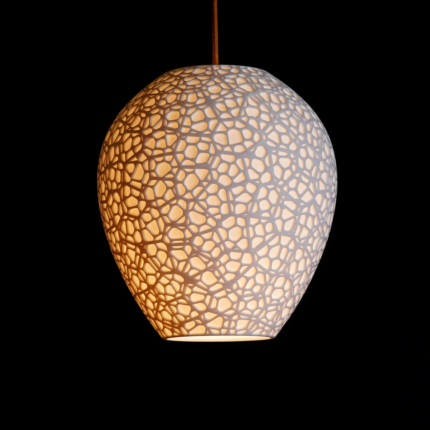 White Cellular Pendant Light illuminated, casting soft ambient glow and highlighting sculptural cellular patterns