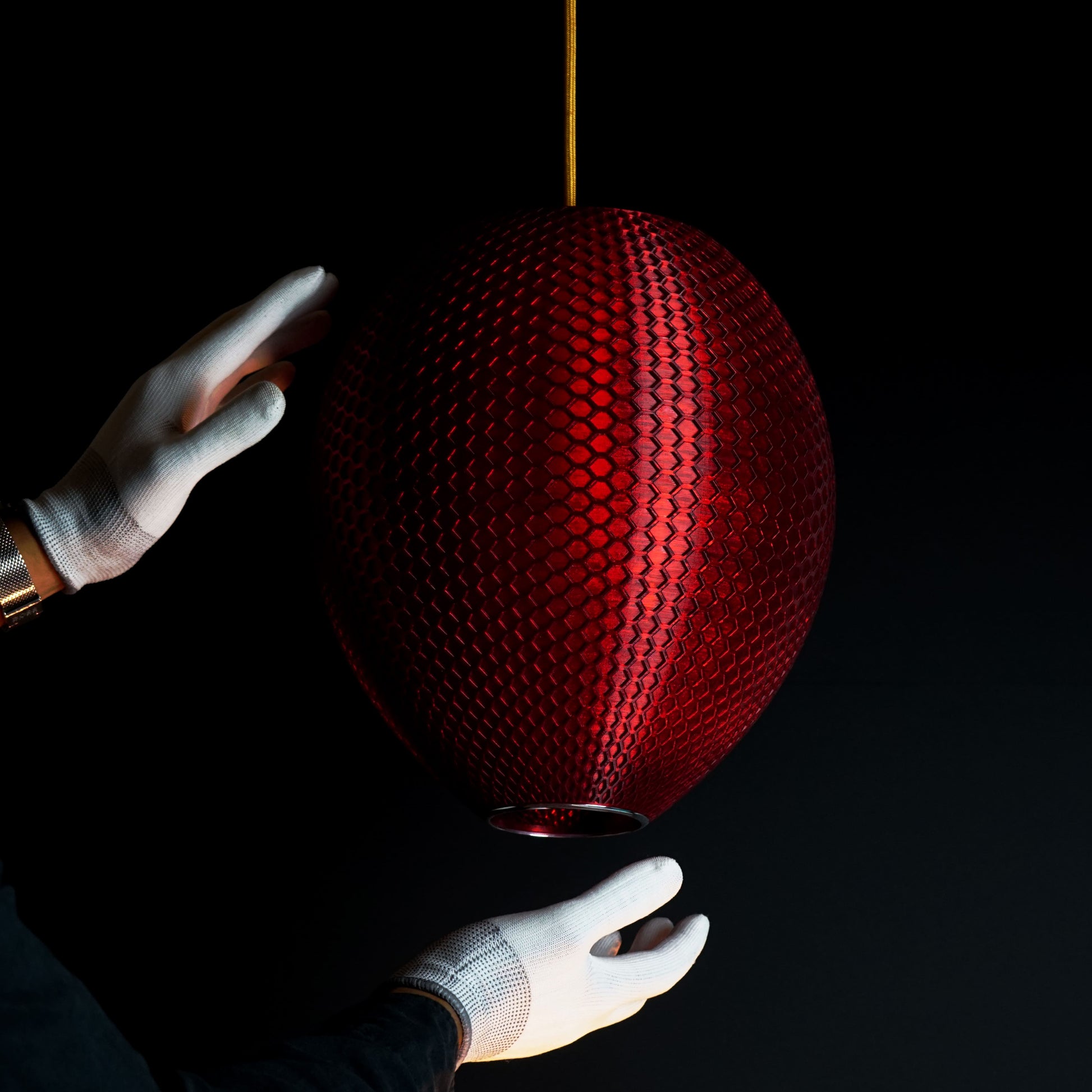 Side view of crimson red sculptural pendant light showing surface detail