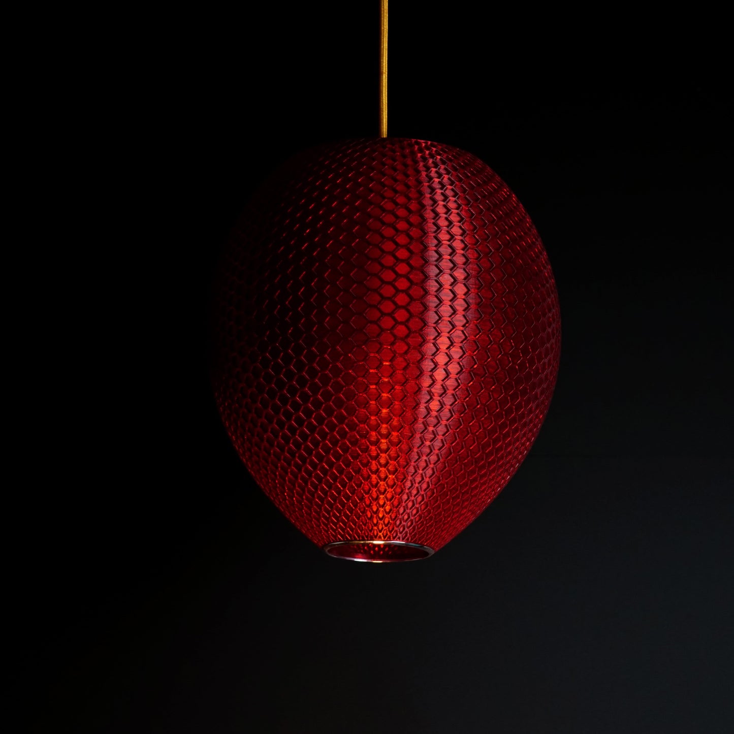 Crimson red sculptural pendant light shown turned off, highlighting design and surface detail