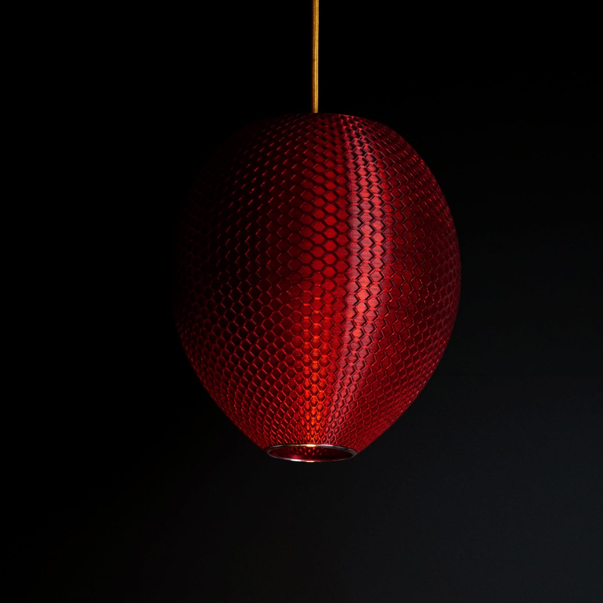 Crimson red sculptural pendant light shown turned off, highlighting design and surface detail