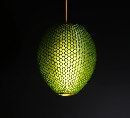 Emerald Green Hive Pendant Light illuminated, casting ambient glow and highlighting geometric honeycomb facets