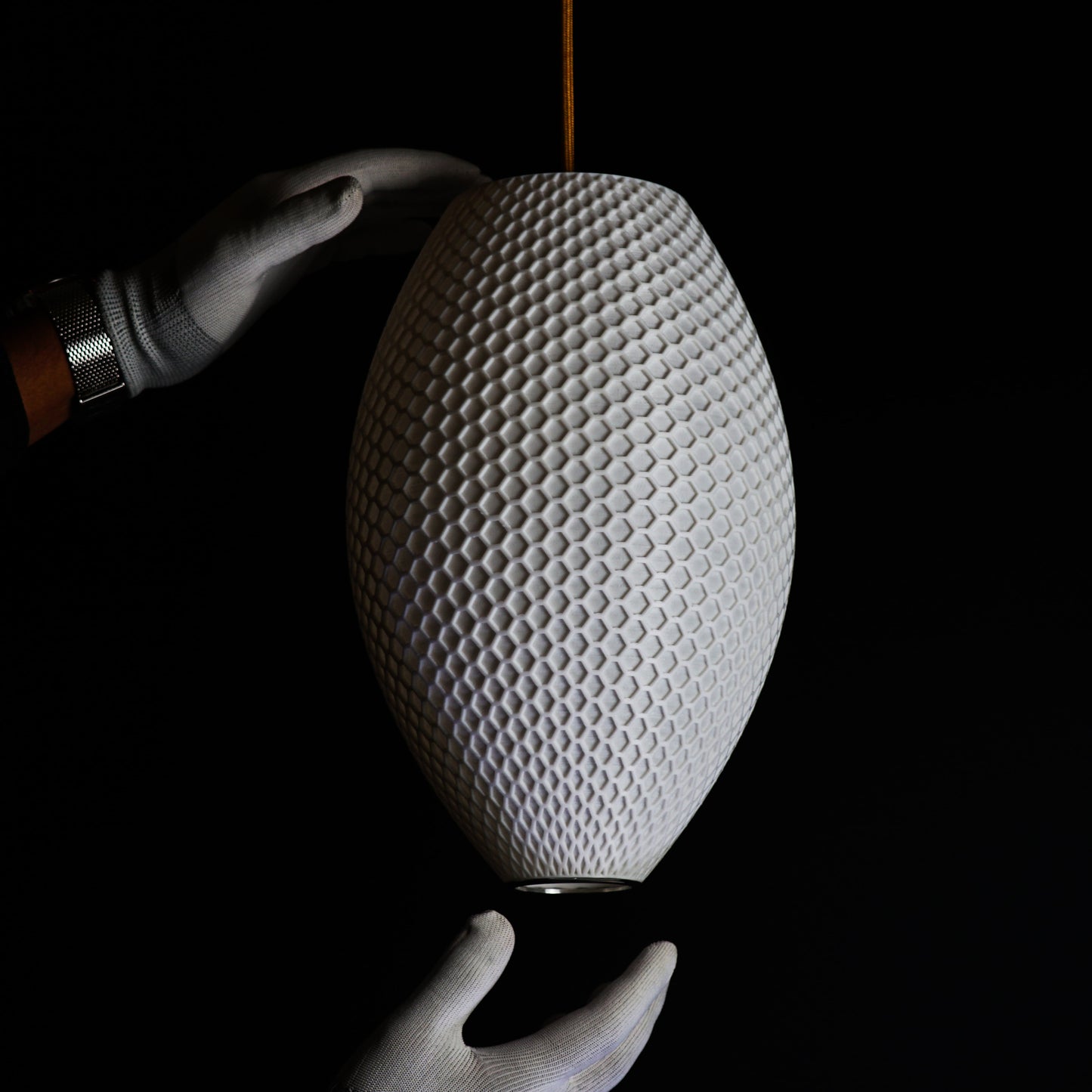 Side view of Long White Hive Pendant Light showing intricate hive-inspired pattern and elongated sculptural form