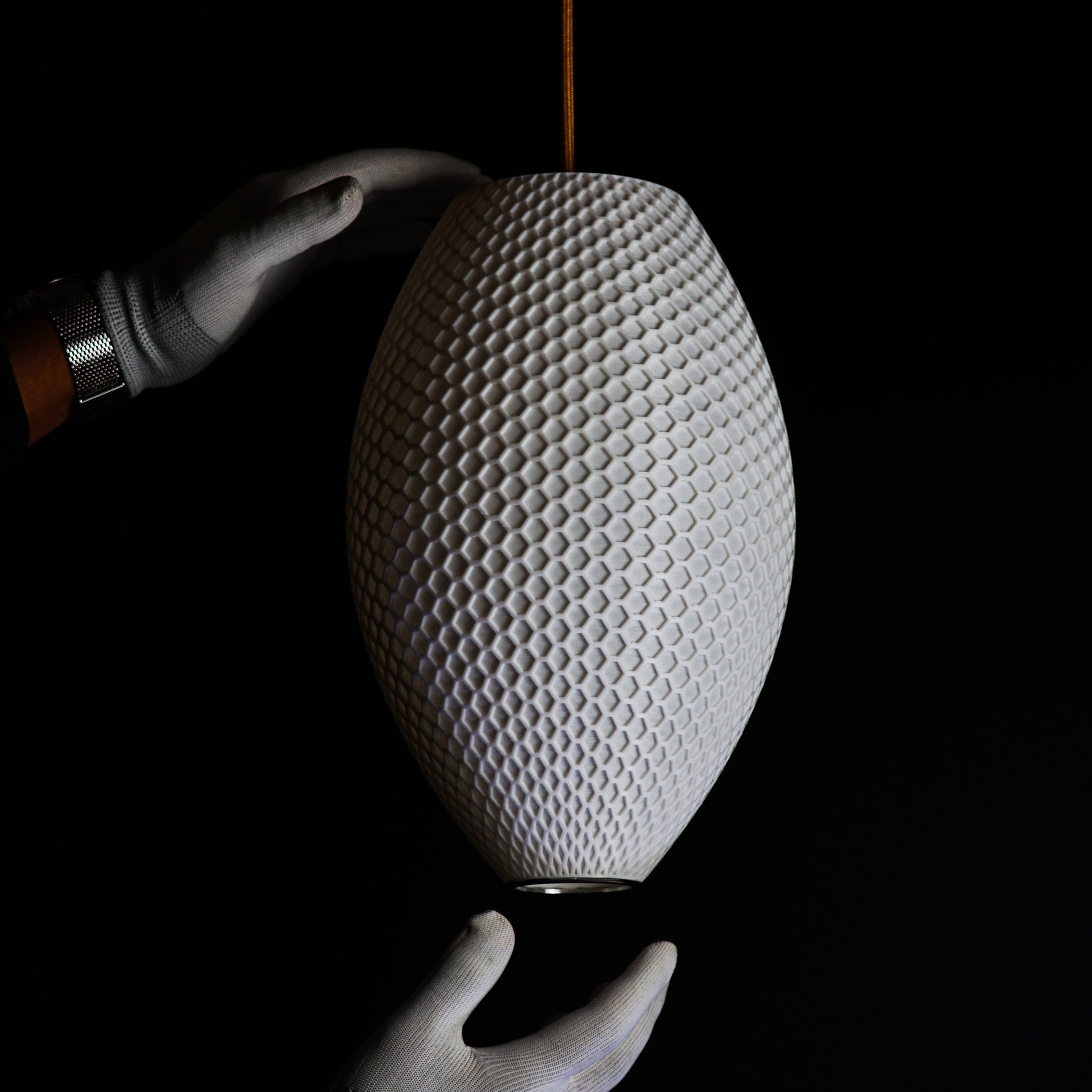 Side view of Long White Hive Pendant Light showing intricate hive-inspired pattern and elongated sculptural form