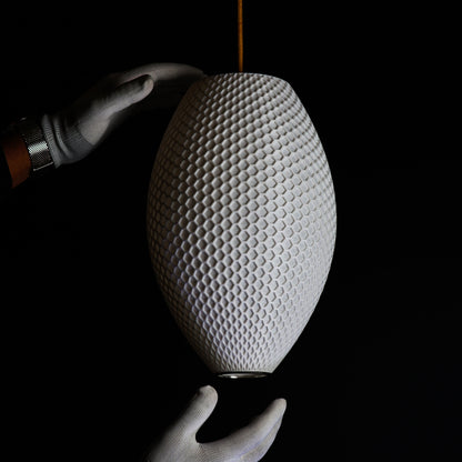 Side view of Long White Hive Pendant Light showing intricate hive-inspired pattern and elongated sculptural form