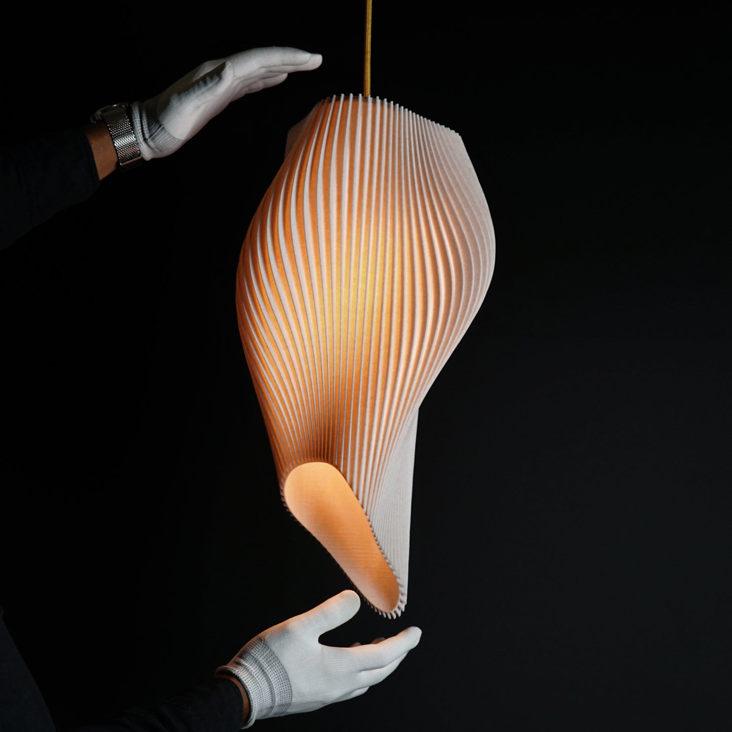 Straw Long Wave Pendant Light illuminated, casting warm ambient glow and highlighting textured sculptural curves