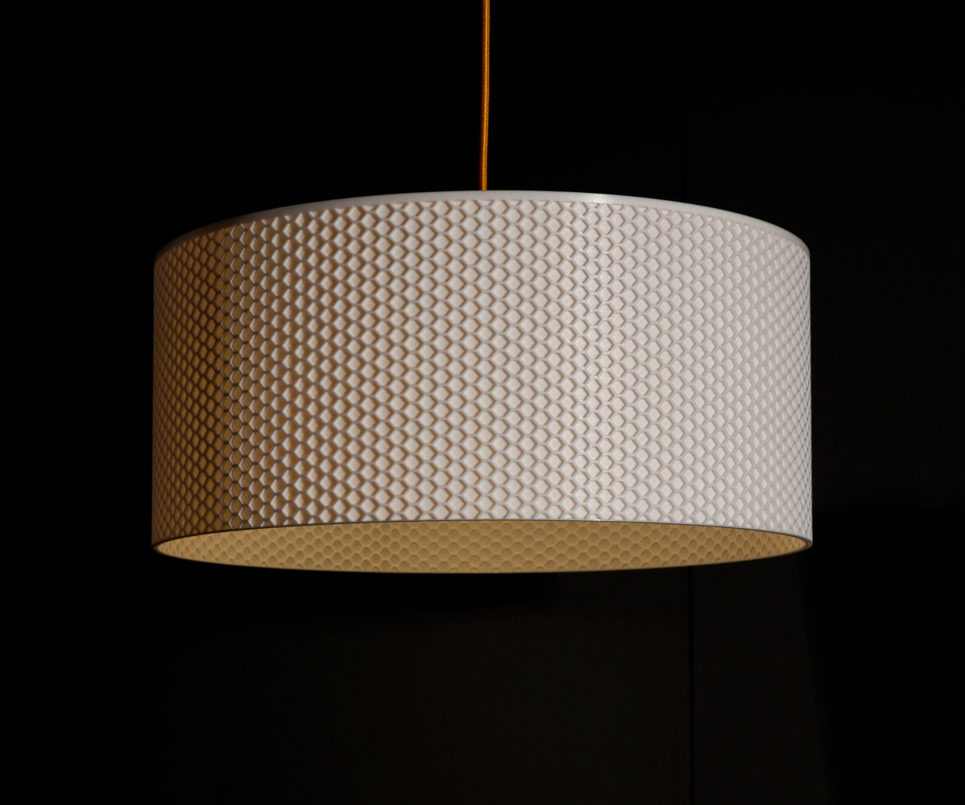 White Drum Hive Pendant Light illuminated, casting ambient glow through geometric hive-inspired pattern